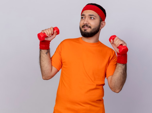 Foto gratuita teso giovane sportivo guardando al lato che indossa la fascia e il braccialetto che esercitano