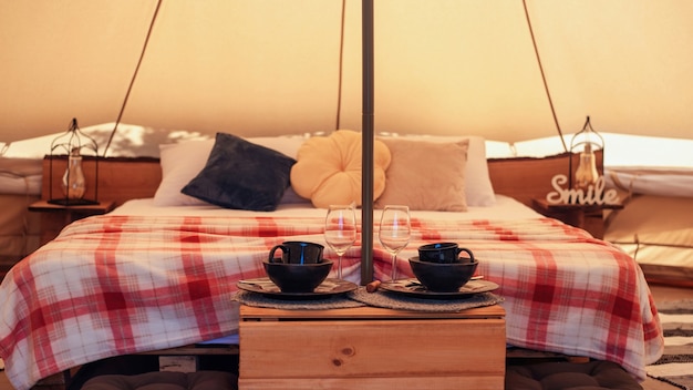 Foto gratuita tenda interna con letto e stoviglie al glamping