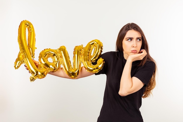 Terrified lady holding love balloon and looking aside