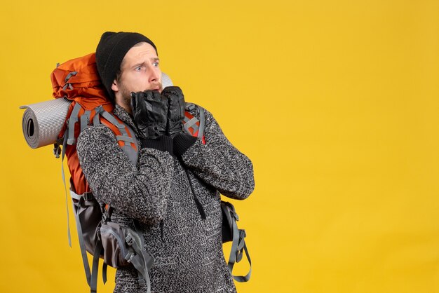 terrified young man with leather gloves and backpack