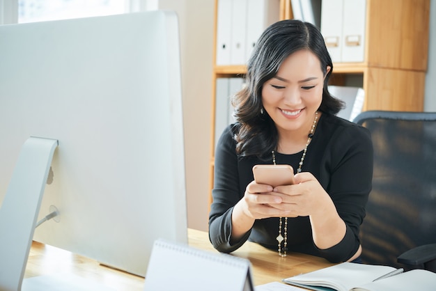 Texting businesswoman at office Texting businesswoman at office
