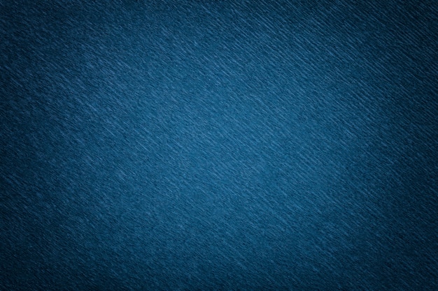 Textural of navy blue background of wavy corrugated paper, closeup.