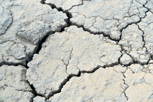 砂漠のひび割れた汚れた粘土の質感。水分不足の概念。