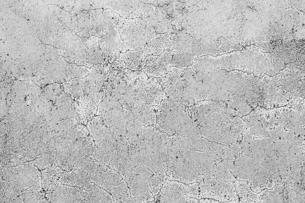 Texture of a grey concrete wall with curly cracks