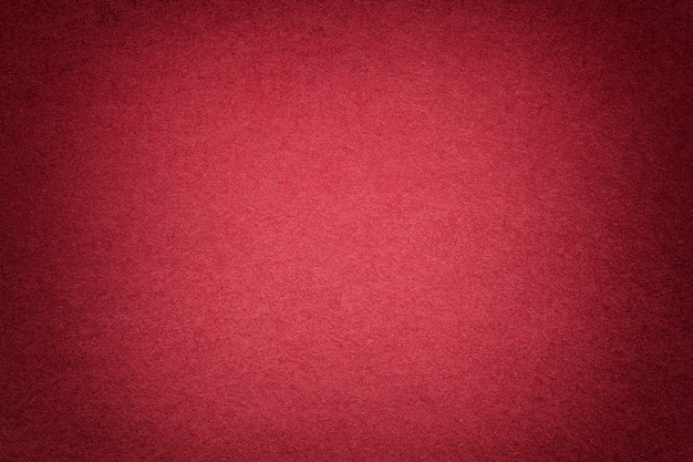 Texture of old bright red paper background, closeup. structure of dense cardboard.