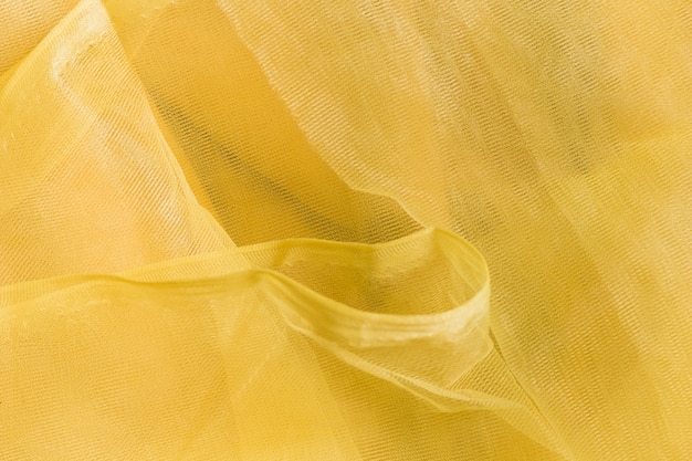 透明な黄色のしわくちゃの生地のテクスチャ