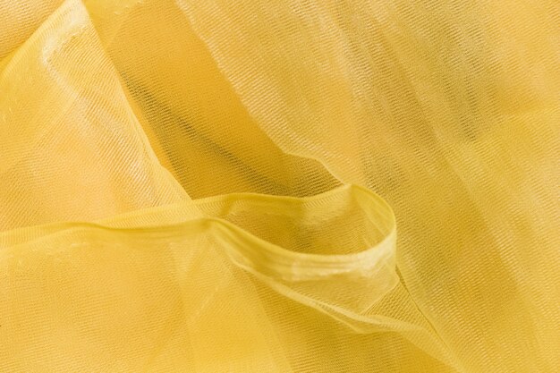 Texture of transparent yellow crumpled fabric