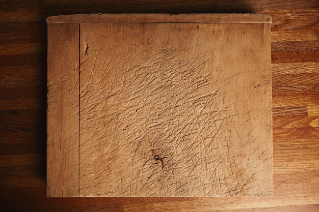 아름다운 갈색 나무 테이블에 깊은 상처가있는 아주 오래되고 많이 사용되는 도마의 질감