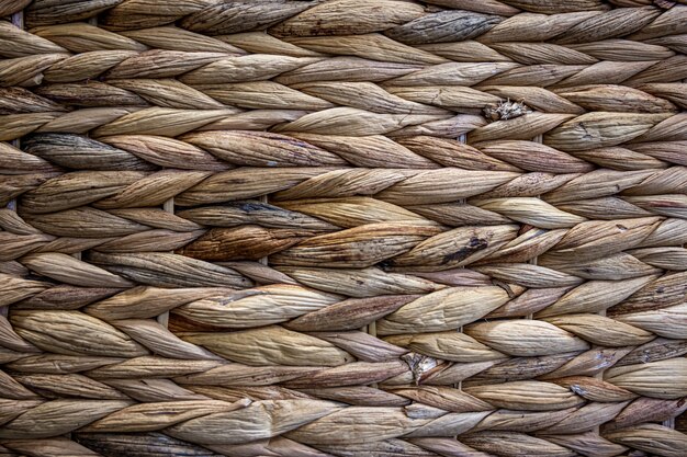 Texture of woven beige straw, background of braids from the plant stem close-up.