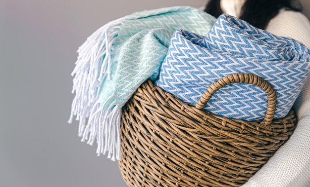 Textured plaids in a wicker basket on a gray background