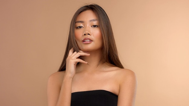 彼女のあごをけん引する理想的な濡れた光沢のある肌を持つタイのアジア人モデル