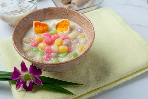 Тайский десерт под названием шарики Bualoy в ковшах с горячим кокосовым молоком и листьями пандана для повышения изысканности.