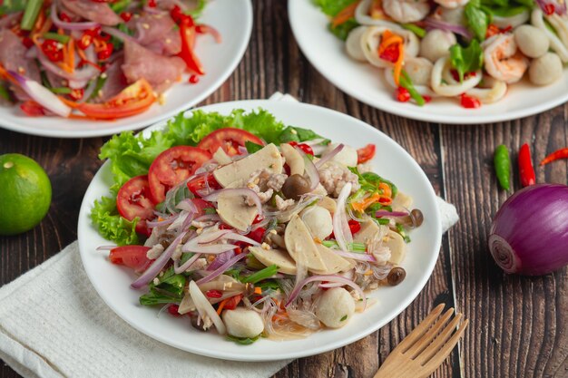 Тайская еда; смешанный пикантный салат из свинины с вермишелью и лапшой
