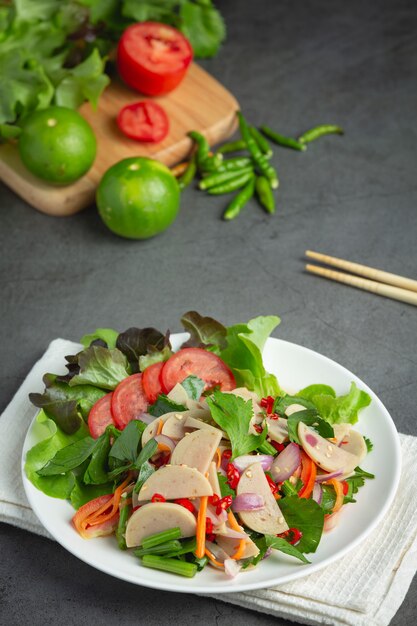 Тайская еда; смешанный острый салат из белых свиных колбасок или YUM MOO YOR