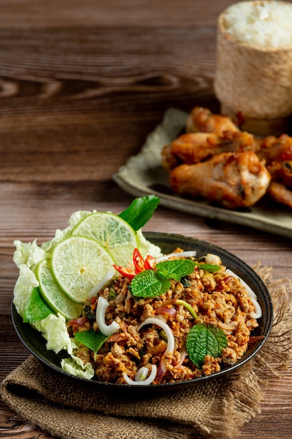 매콤한 다진 돼지 고기를 곁들인 태국 음식에는 찹쌀과 프라이드 치킨이 함께 제공됩니다.