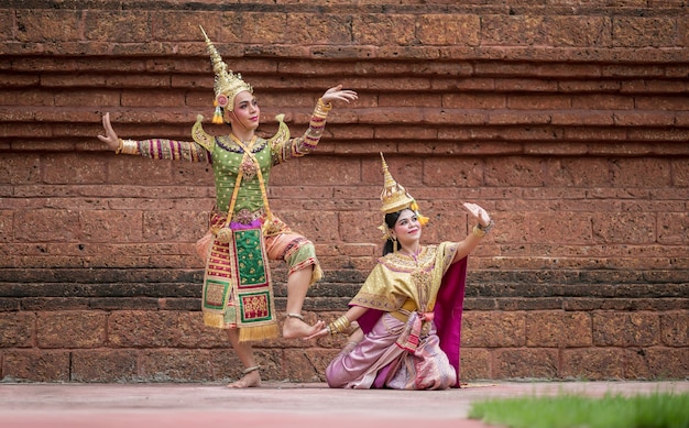 Foto gratuita thailandia coppia danzante in spettacoli khon mascherati con antico tempio