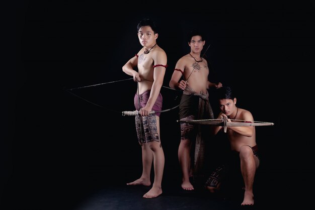 Thailand men warriors posing in a fighting stance with weapons