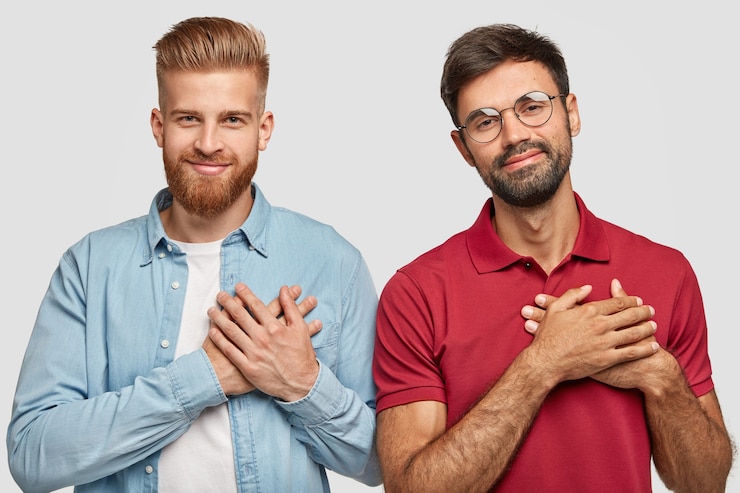 Free Photo thankful bearded brothers posing against the white wall