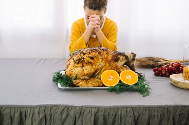 Thanksgiving dishes with woman praying