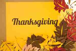 Free photo thanksgiving lettering with big leaflets on yellow paper