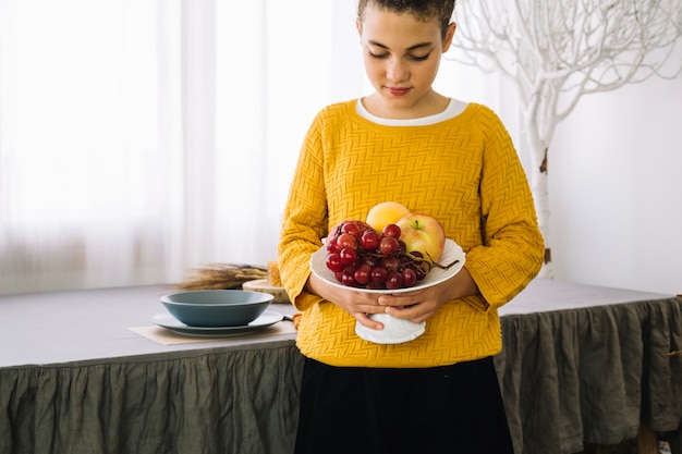 Free photo thanksgiving table decoration with woman holding fruits