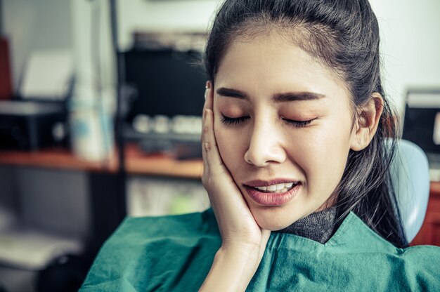 Free photo that woman had a toothache and a hand touch her cheek.