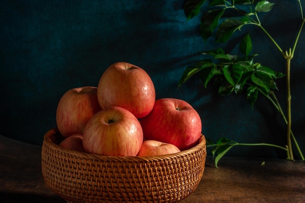 접시 위의 사과는 나뭇결 테이블의 희미한 조명 아래에서 유화처럼 보입니다.