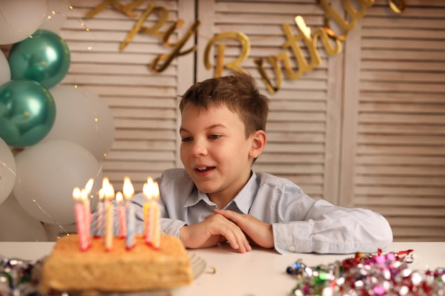 소년은 생일 케이크의 초를 끄고 소원을 빌며 화환을 든 공을