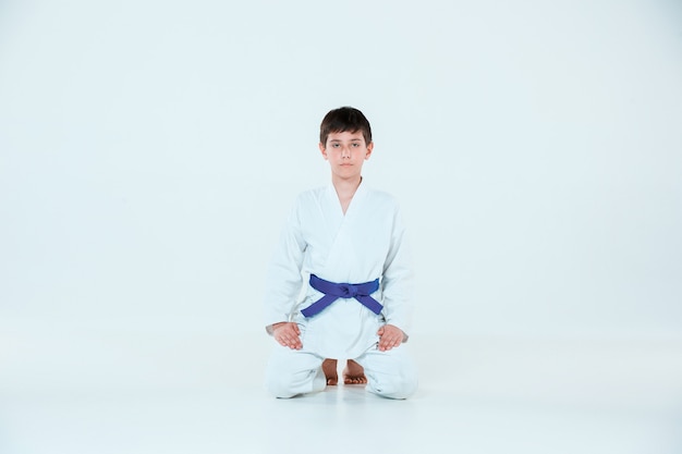 Мальчик позирует на айкидо на тренировке в школе боевых искусств. концепция здорового образа жизни и спорта