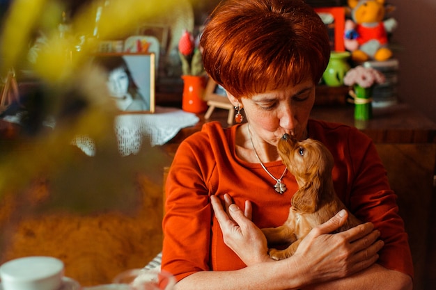 Бесплатное фото Очаровательная леди, обнимающая маленькую собачку