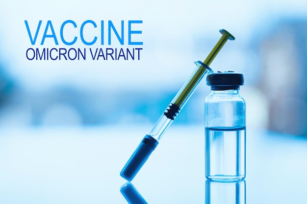 南アフリカ​の​コロナ​ウイルス​変異体​に対する​新​世代​ワクチン​の​概念​。 sars​-​cov​-​2​の​オミクロン​変異体​。​窓​の​背景​と​青い​ガラス​の​テーブル​に​薬​と​注射器​の​バイアル​。