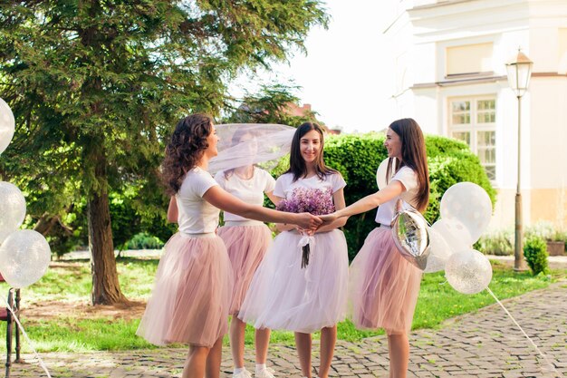 Милая невеста с друзьями на девичнике весело проводит время в летнем парке