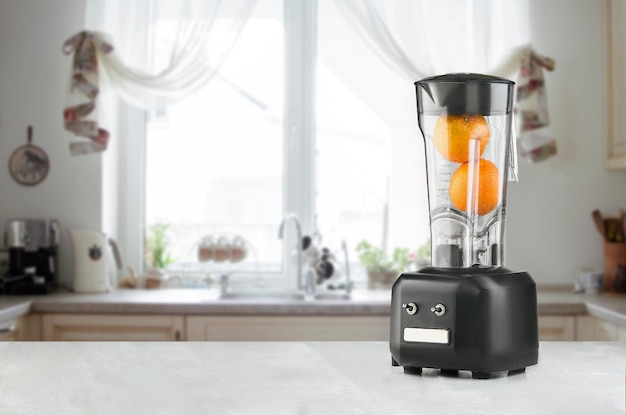 Бесплатное фото Электрический блендер для приготовления фруктового сока или смузи на кухонном столе. концепция здорового питания