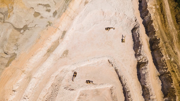 Полет дрона над карьером из песка и белого камня на изображении видны остановленные экскаваторы, вид с воздуха на каменно-песчаную промышленность