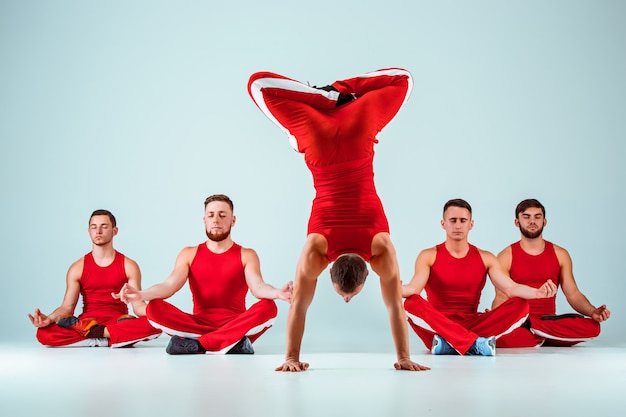Бесплатное фото Группа гимнастических акробатических кавказских мужчин в позе равновесия