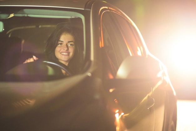 Счастливая женщина водит машину. вечер ночное время