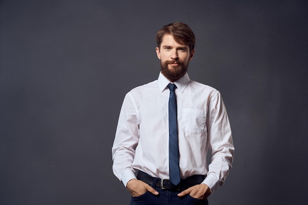 Мужчина в костюме с галстуком в офисе на темном фоне