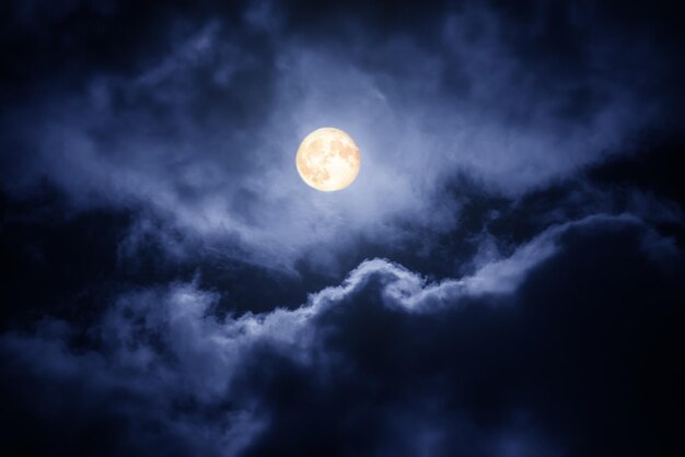 구름 사이의 어두운 하늘에 있는 달, 자연적인 추상적 배경