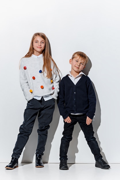 Бесплатное фото Портрет милый маленький мальчик и девочка в стильной джинсовой одежде позирует