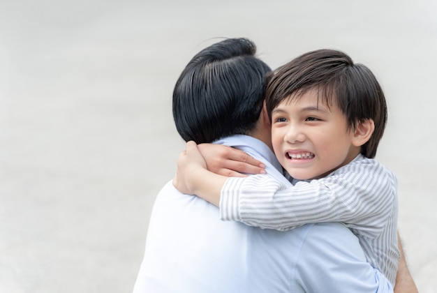 息子は彼の父を抱きしめて幸せな、独身のお父さんと息子の幸せアジアの家族の概念を満たします