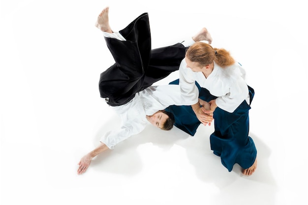 Бесплатное фото Двое мужчин сражаются на тренировках по айкидо в школе боевых искусств.