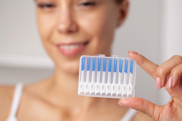 女性は歯間スペースを掃除するためにブラシを使用します。