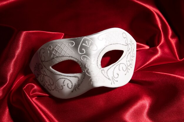 Театральная маска на красном занавесе