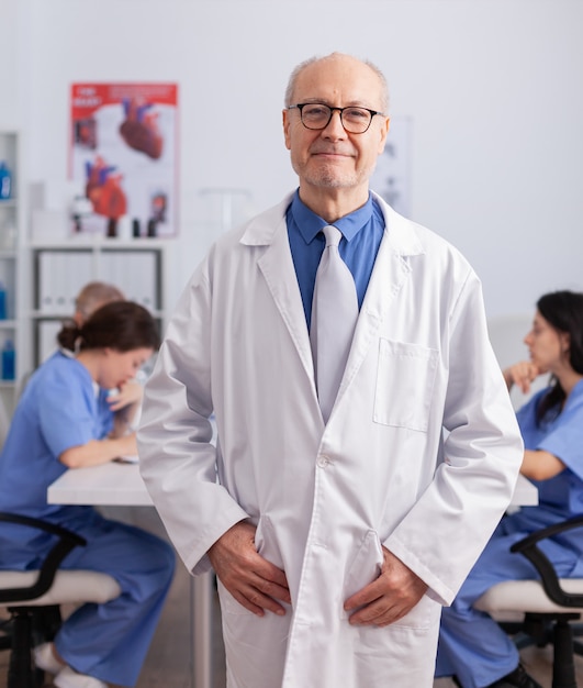 Therapist senior man standing in front of camera analyzing surgery symptom