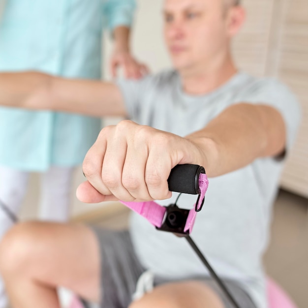 Free photo therapist undergoing physical therapy with male patient