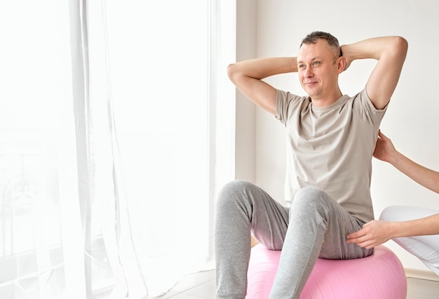 Therapist undergoing physical therapy with male patient