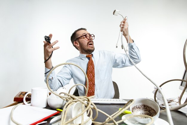 There are a lot of wires in the workplace and man is constantly tangled in them