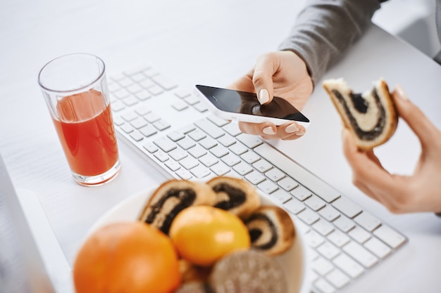 There is no time to relax. Major member of company got ill and working from home, can not distract for break so she eats lunch while searching information in smartphone and working with computer