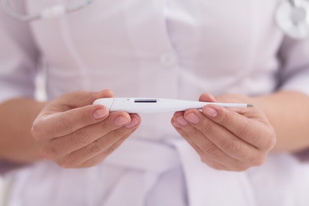 Thermometer in hands of female nurse