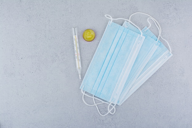 Thermometer, masks and vaseline on marble background. 